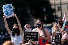 Abortion rights supporters hold up signs as they gather for a pre-march rally of the annual Women's March on Oct. 2 in Washington, D.C. | Joshua Roberts/Getty Images